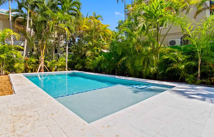 Turquoise swimming pool framed by palms